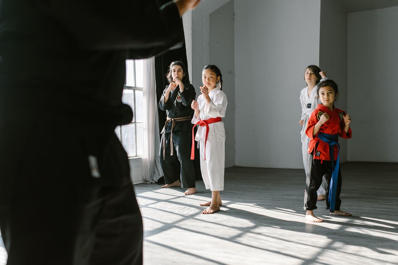 Các em nhỏ tập võ cùng HLV trong dojo ngập ánh sáng (ảnh minh họa)